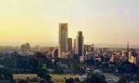 Photo showing skyline of Nairobi, Kenya. Foreground shows city parks, buildings, background is clear sky.